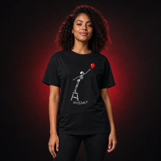 Woman wearing Almost Had It funny skeleton Halloween T-shirt in a red-lit studio
